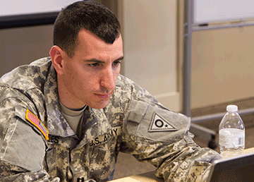 Ohio Army National Guard Capt. Nicholas Oles surveys statistical progress of training on his computer.