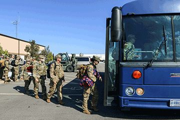 Soldiers of the 1483rd Transportation Company board a bus.