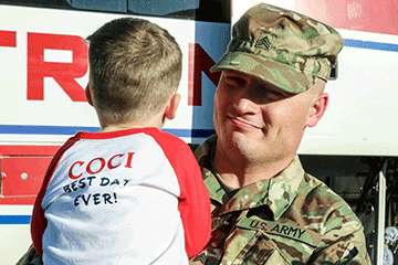 Soldier holds boy.