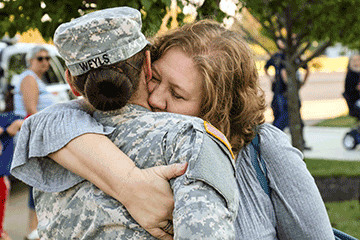 Female Soldier hugs woman.