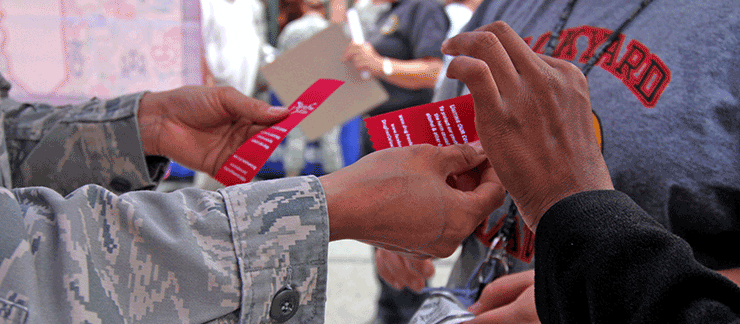 Close up of Air guard member handing ribbons to participants.