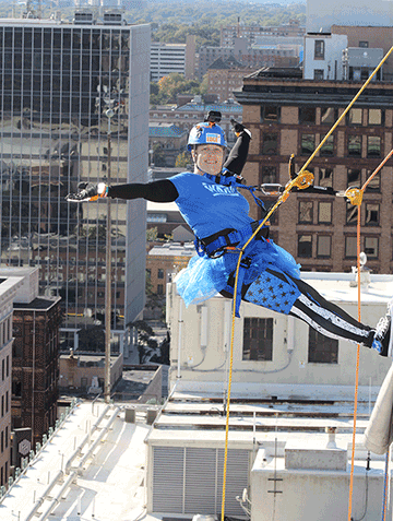Sgt. 1st Class Wendy Hernandez rappels off the side of a 16-story building wearing a blue tutu.