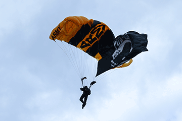 Members of the U.S. Army’s Golden Knights parachute team perform an aerial demonstration for the crowd before delivering the game ball.