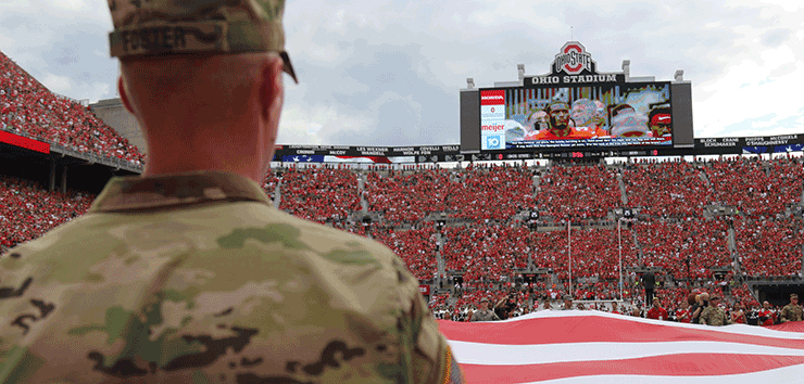 Ohio National Guard members hold a large American flag during pregame ceremonies.