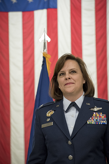 Col. Allison Miller stands in front of an American flag.