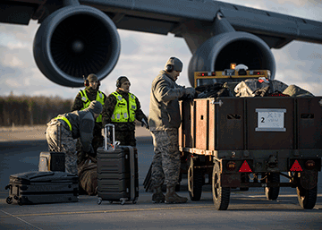Airmen unloading plane into carts.