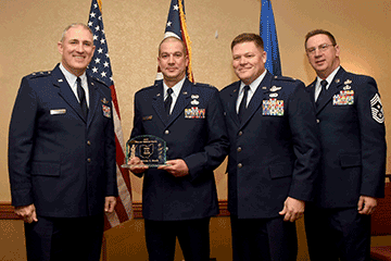 Capt. Marcus Bosch, Ohio Air National Guard Company Grade Officer of the Year holds award while posing with Maj. Gen. Stephen E. Markovich, Col. James R. Camp and Chief Master Sgt. Thomas A. Jones.