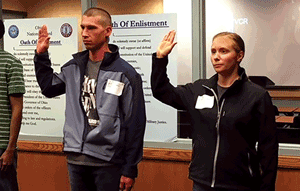 Nate and Irene Miller of Geauga County, Ohio take the oath together with right hands raised in recruiter office.