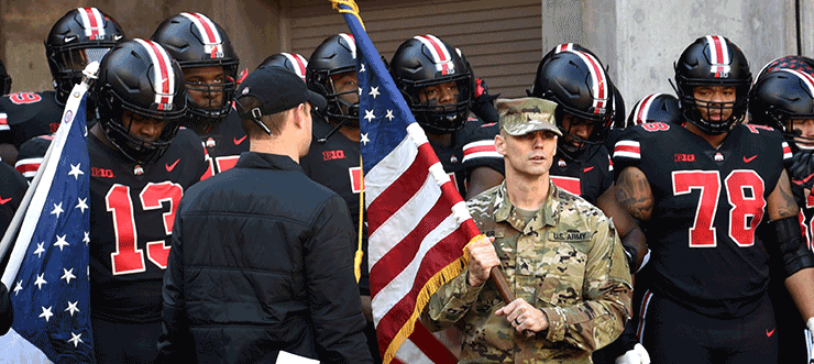 Sgt. Benjamin Tiller, the Ohio Army National Guard Noncommissioned Officer of the Year, prepares to carry the American flag on to the field and lead The Ohio State University football team out of the tunnel before its game.