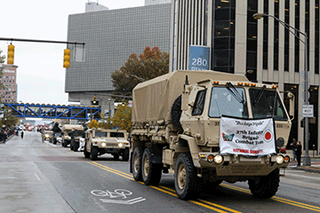 Ohio Army National Guard vehicles roll down the street.