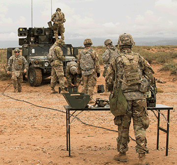 Soldiers stand around a vehicle on missle range.
