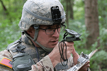 Closeup of Soldier looking at compass in forest.