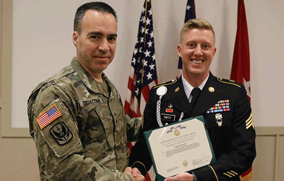 Commander shakes hands with NCO of the year.