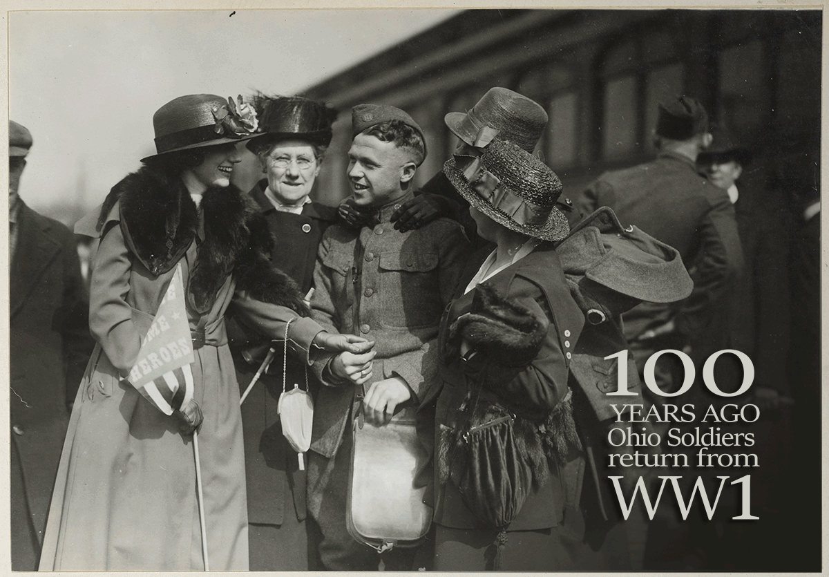 Historic black and white photo of female family members greeting Soldier returning. 