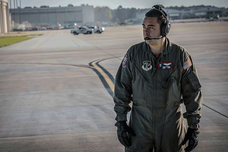 Loadmaster stands on tarmac in the early sun.