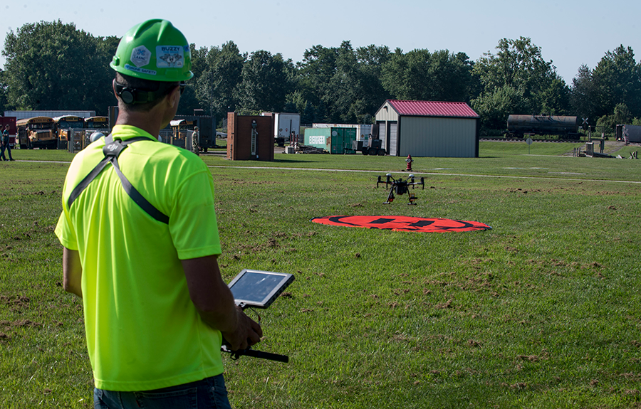 Man in bright t shirt operates aerial video surveillance device.