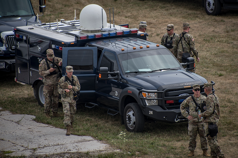 Soldiers exit emergency vehicle in field.