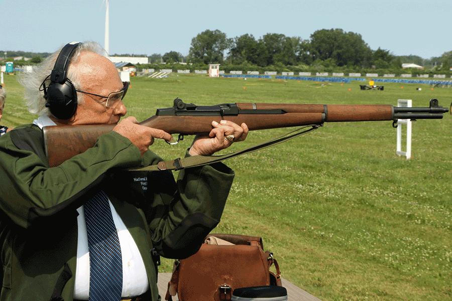 Profile of man shooting rifle
