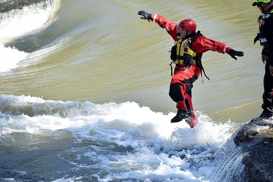 An Airman jumps into swift water. 
