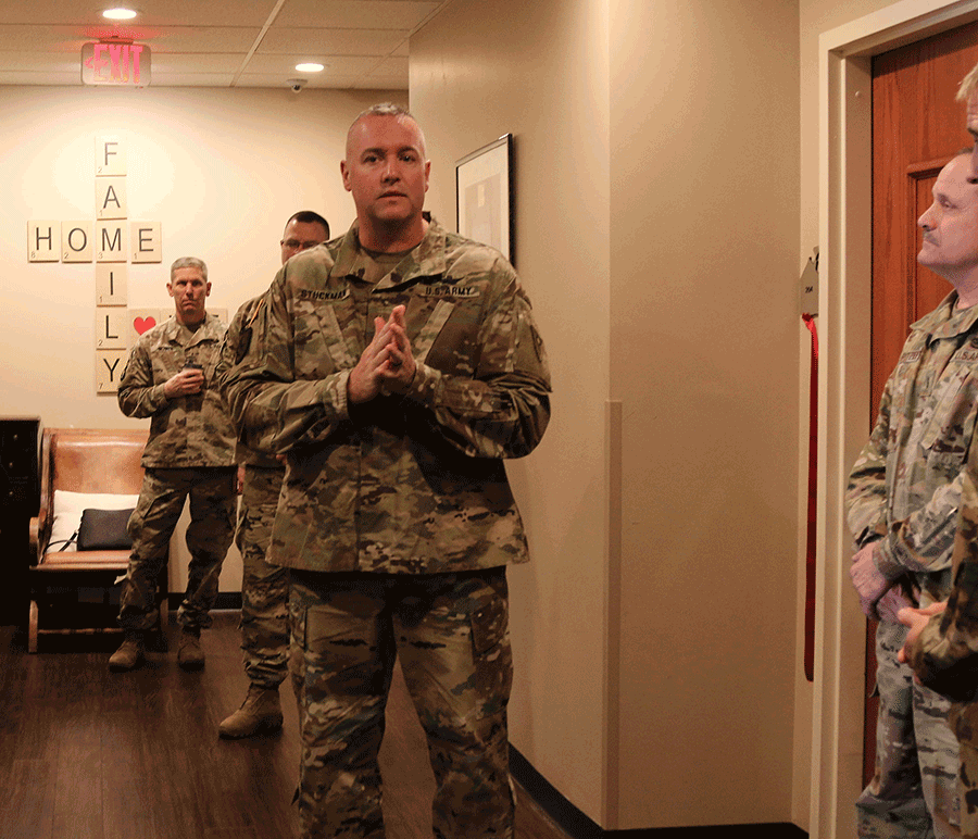 Chief Warrant Officer 5 Jay Stuckman addresses attendees in hall outside room 204.