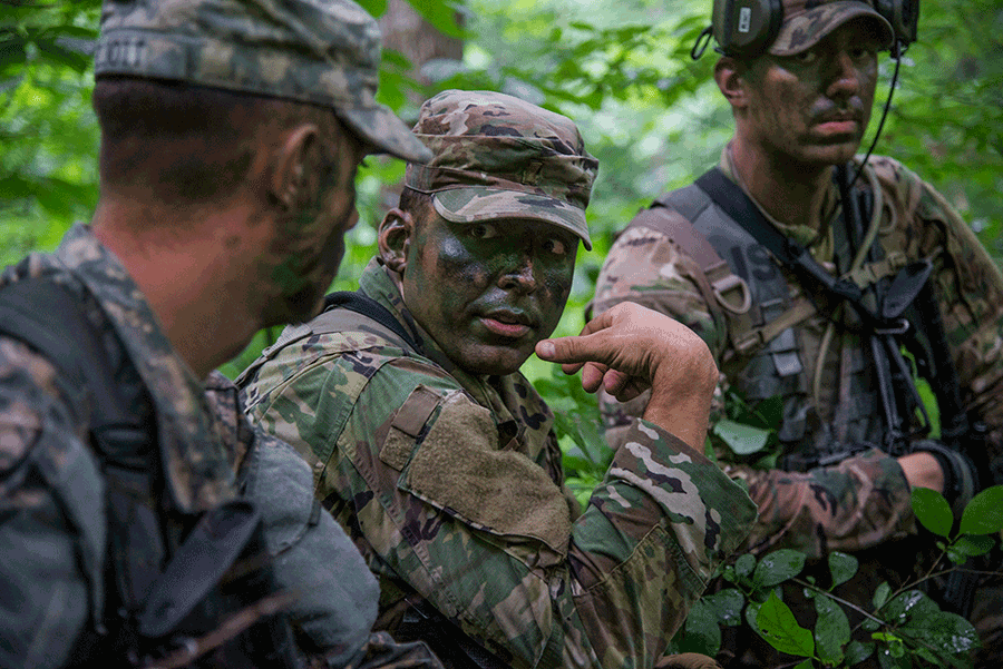 Three Soldiers in camo in a forest.