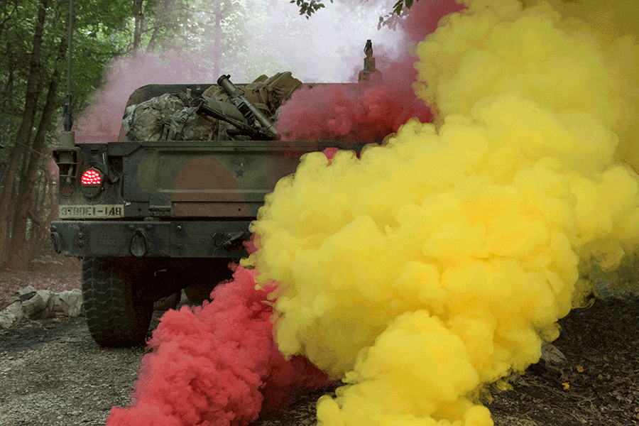 Yellow and red smoke surround vehicle in forest.