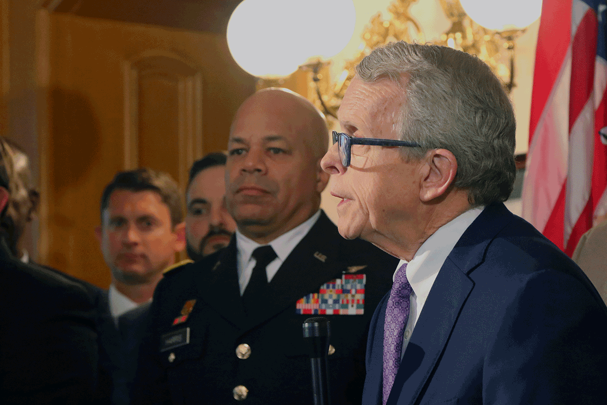 Governor Mike DeWine speaks as Maj. Gen. John C. Harris, Jr and others gather around.