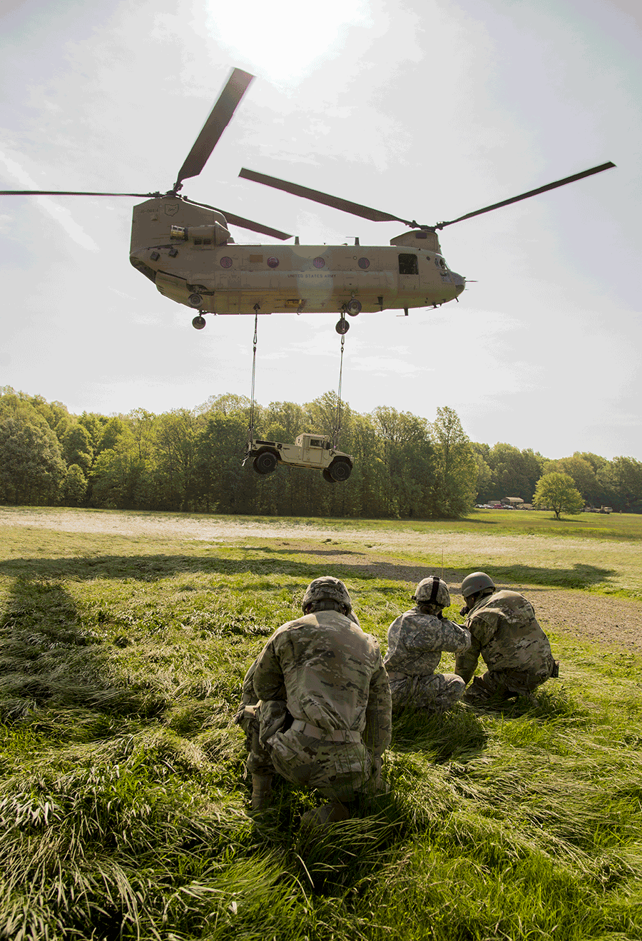 Soldiers observe the load they connected to a CH-47 Chinook helicopter.