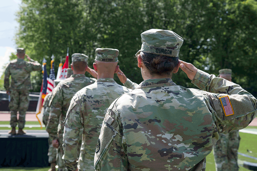 Soldiers salute flag.