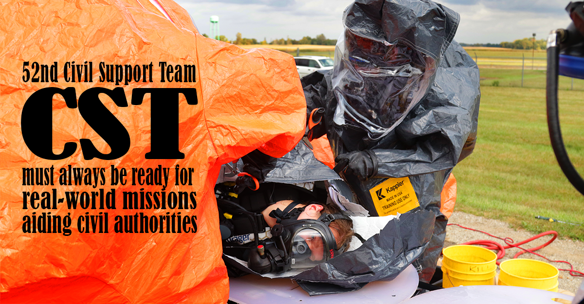 Team in hazmat suits decontaminate a simulated casualty on gurney
