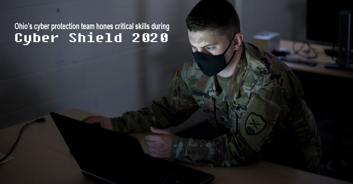 Soldier sits at laptop in the dark.