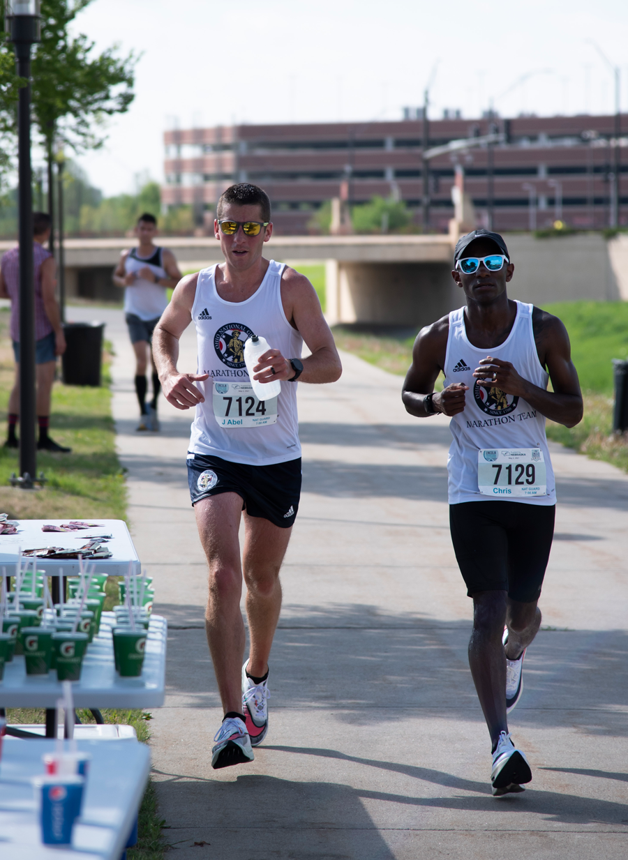 Staff Sgts. Jerrod Abel (left) and Aaron “Chris” Edwards run past a water station.