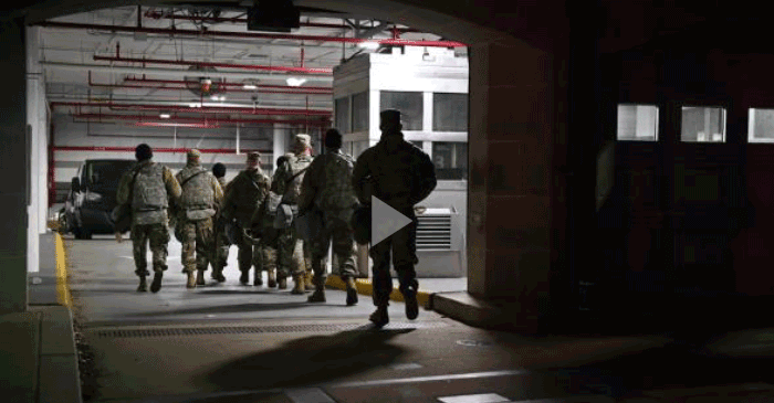 Still from video- Guard members walking through parking garage.