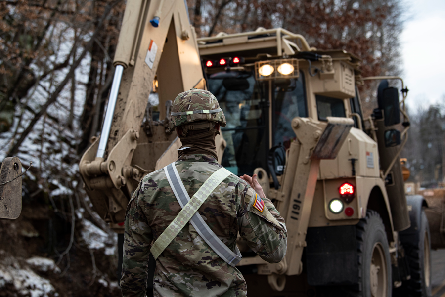 Soldier directs equipment operator.