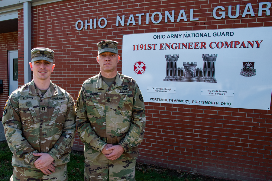 Soldiers stand by 1191st Engineer Brigade banner on building.