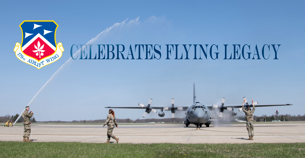 A C-130H Hercules is sprayed with an arc of water by firefighters while on tarmac, Headline reads: 179th Airlift Wing Celebrates Flying Legacy.