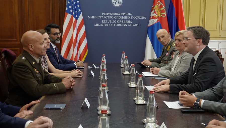 Maj. Gen. John C. Harris Jr.  sits at conference table with Serbian leaders.