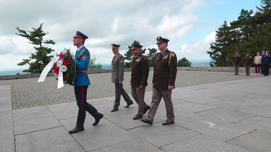 Serbian Armed Forces member carries a wreath to lead a procession.