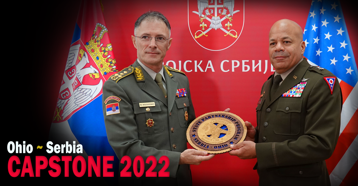 Gen Harris and Serbia leader hold plaque.
