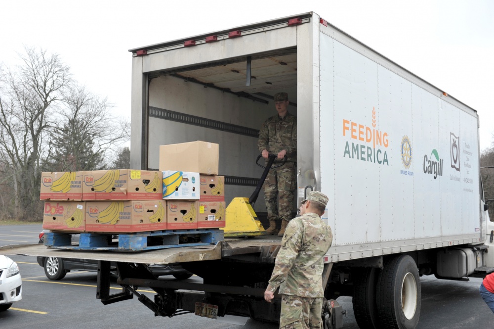 Soldiers unload semi-trailer.