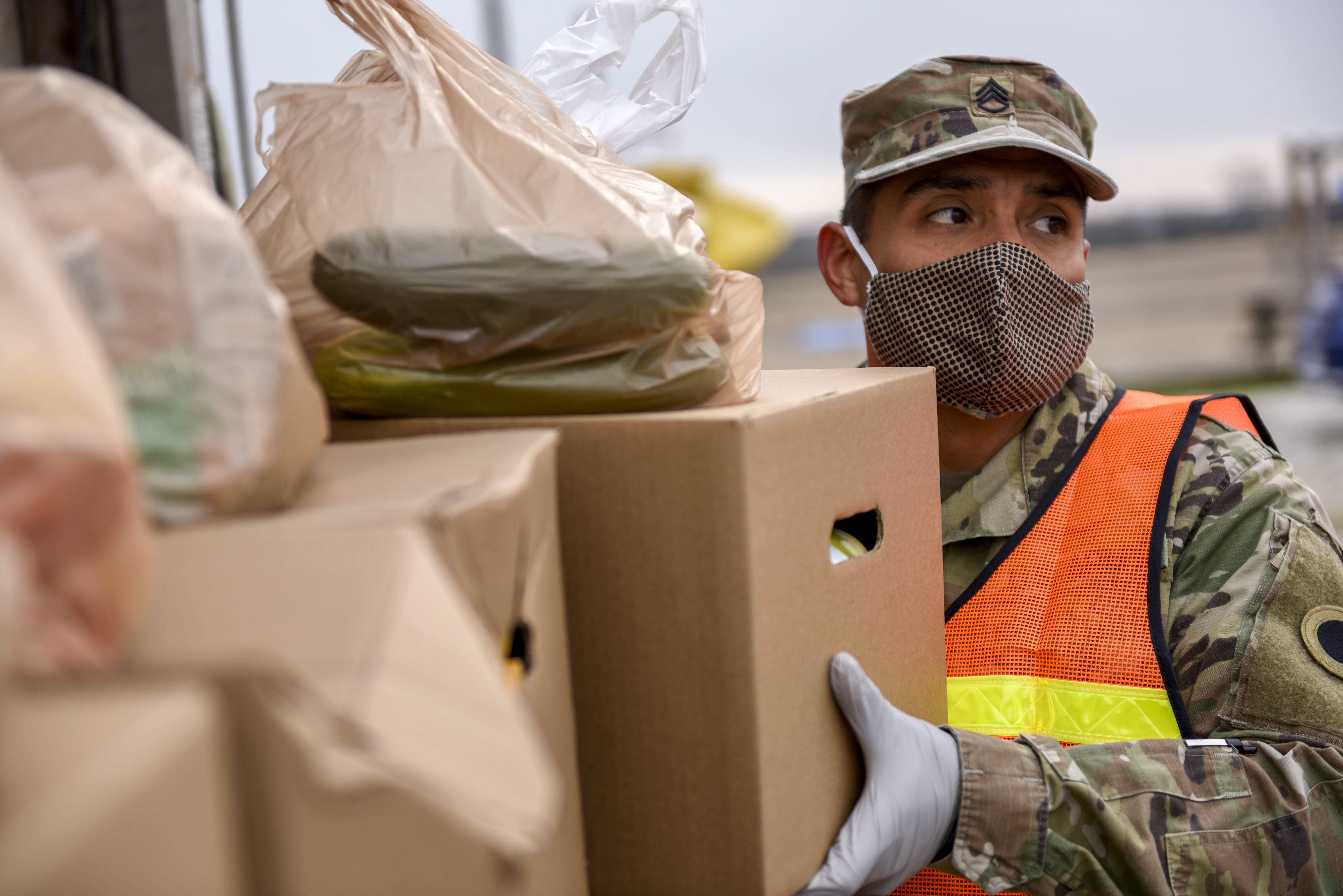 Soldiers unpack groceries at food bank.