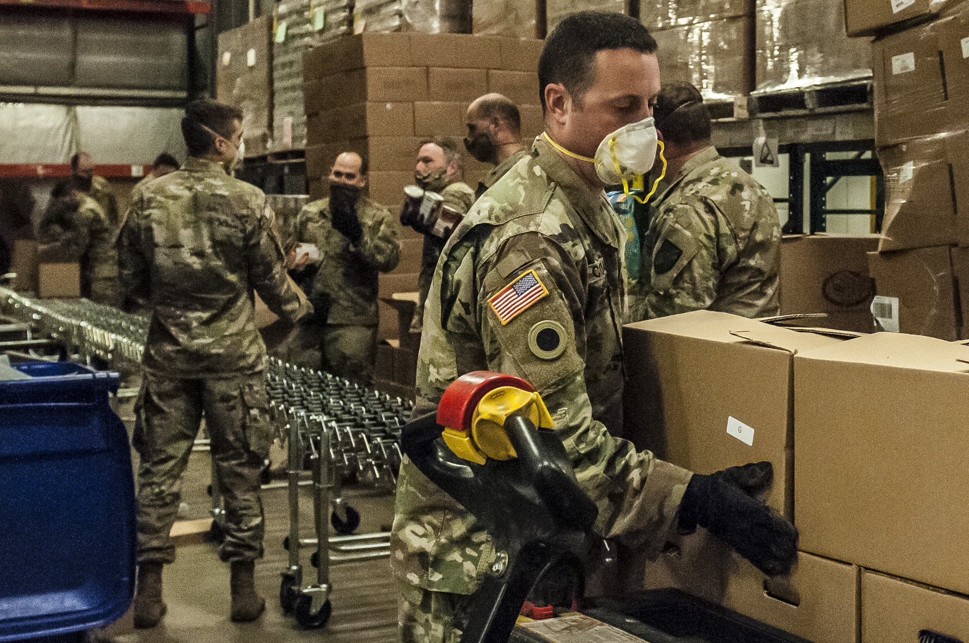 Soldiers pack boxes in assembly line.