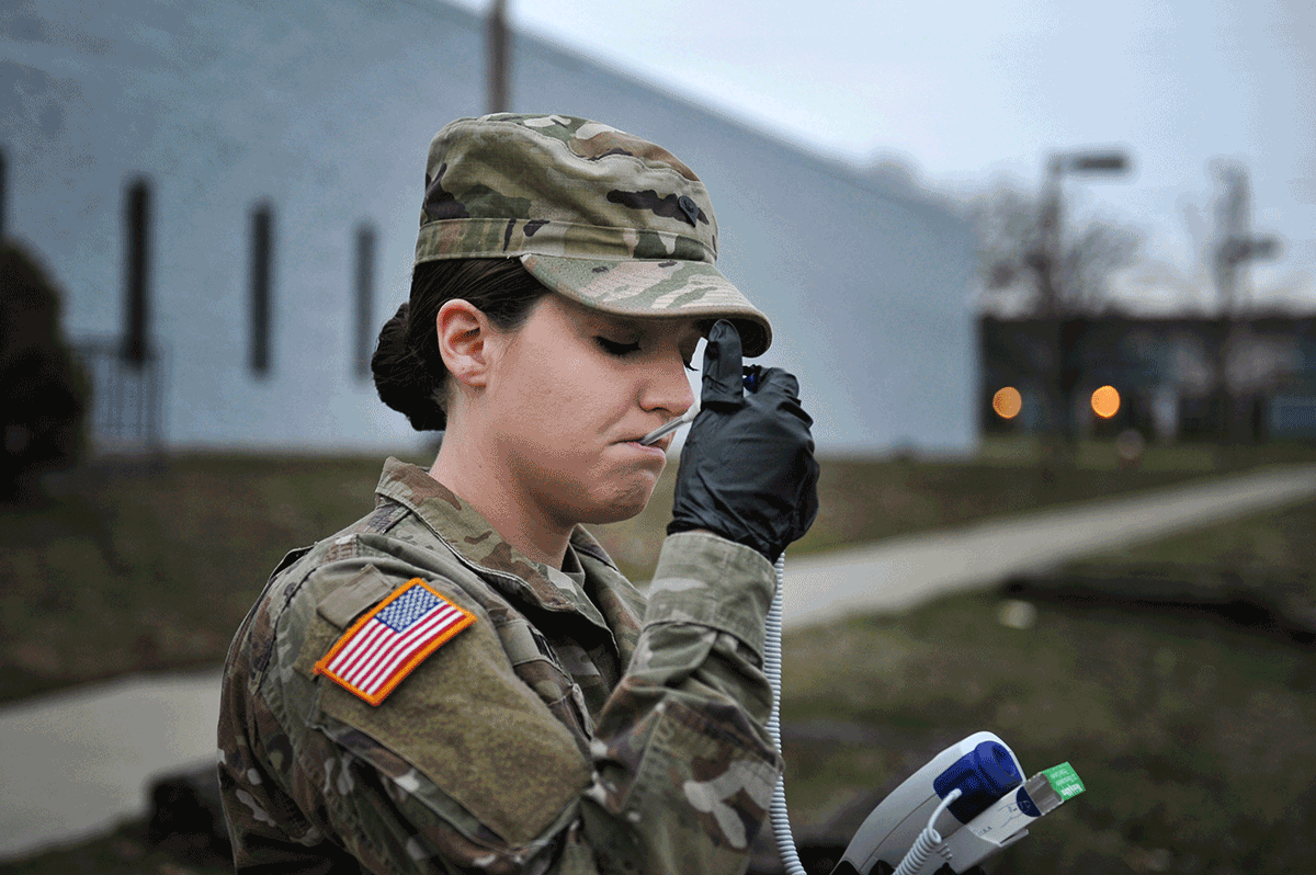 Female Soldier takes her temperature.
