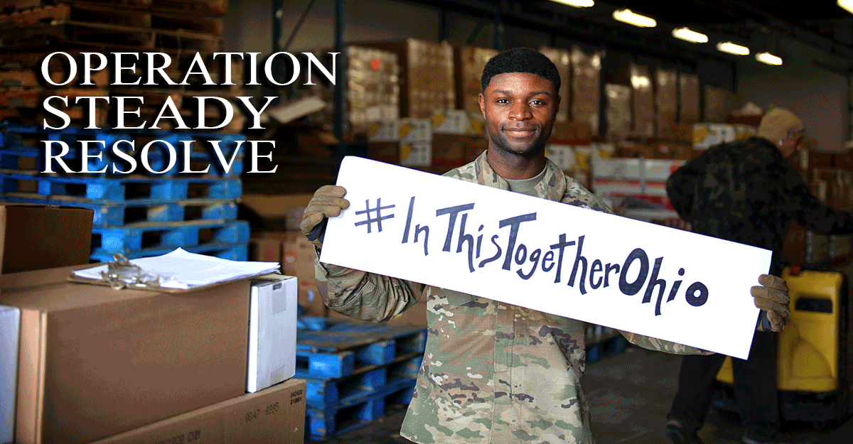 Soldier holds up sign in warehouse saying #InThiSTogetherOhio