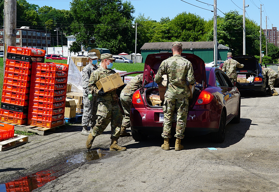 Soldiers load trunks with groceries.