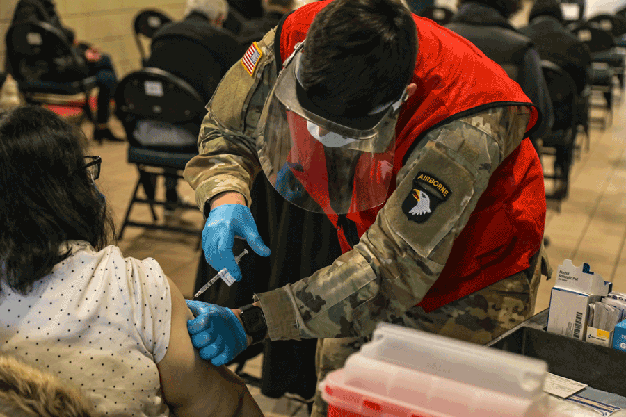 Guard member administers vaccine.
