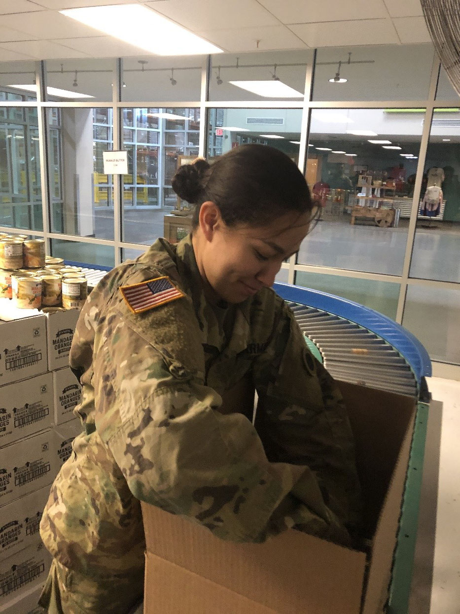 Soldiers loading boxes in warehouse.