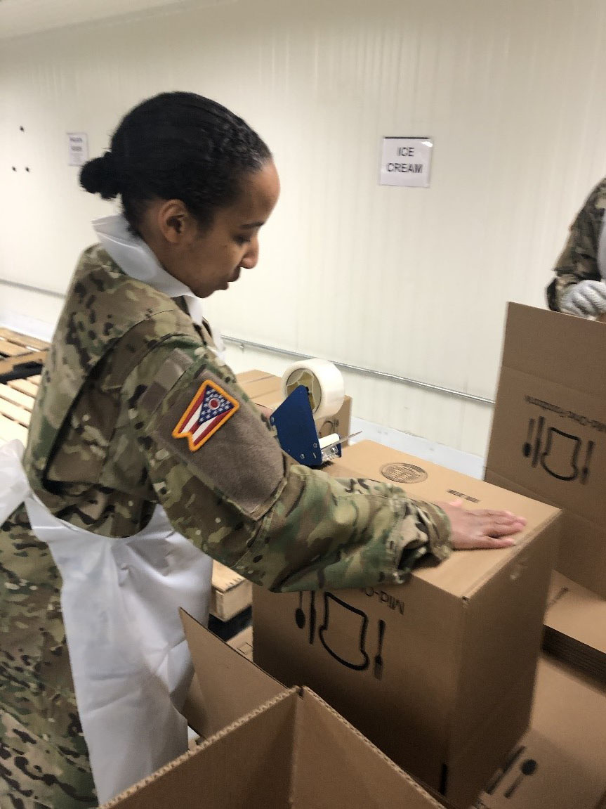 Soldier builds boxes in warehouse.