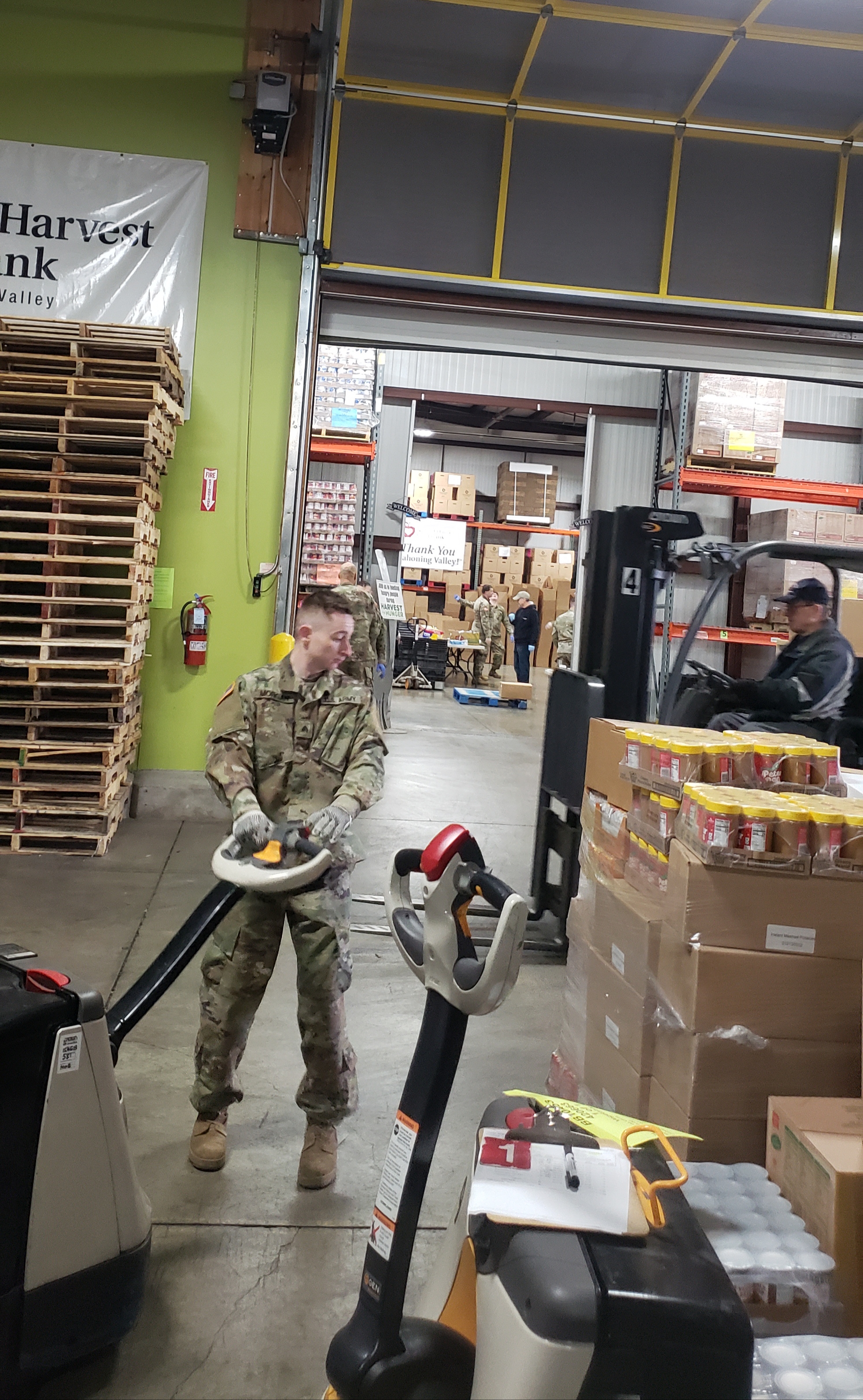 Solider  moves pallets of food.