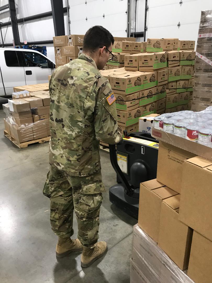 Soldiers moves pallets with hand truck.